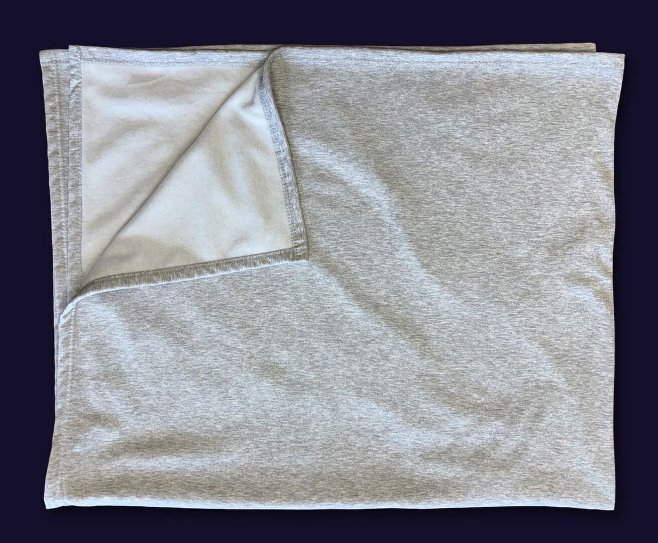 Light gray folded fleece blanket with turned corner